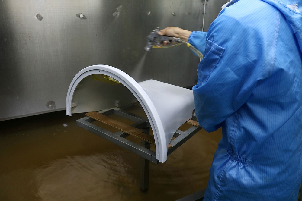 a factory worker applying a spray painting