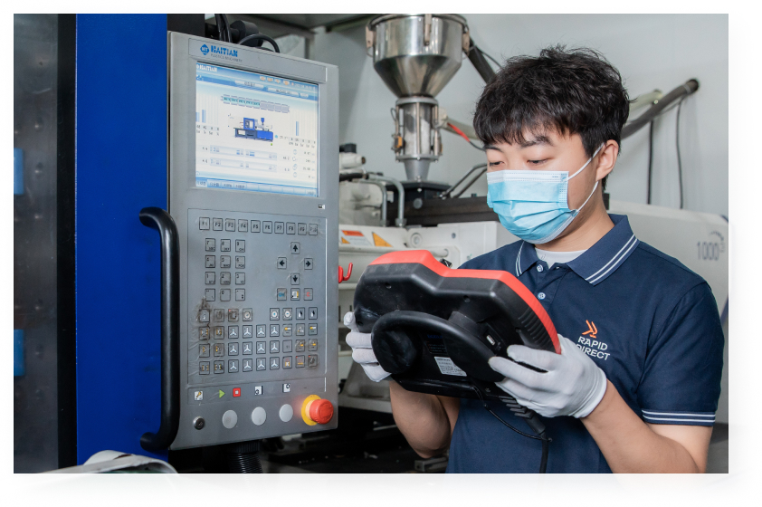 The employee is doing the debugging of the injection molding machine